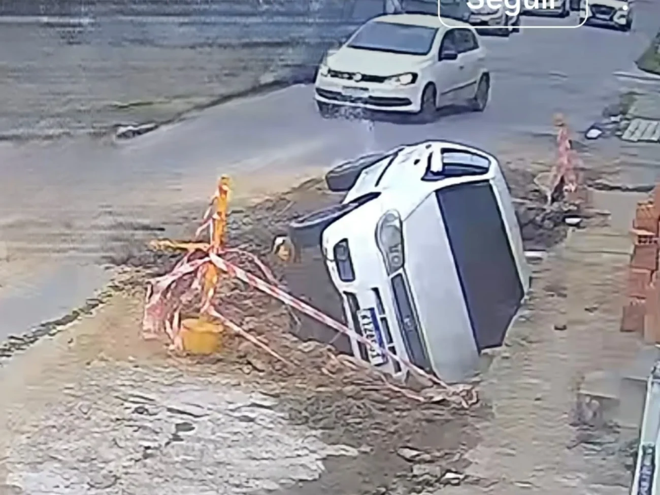 Vídeo mostra carro cai em buraco durante obra e câmera de segurança registra momento impressionante